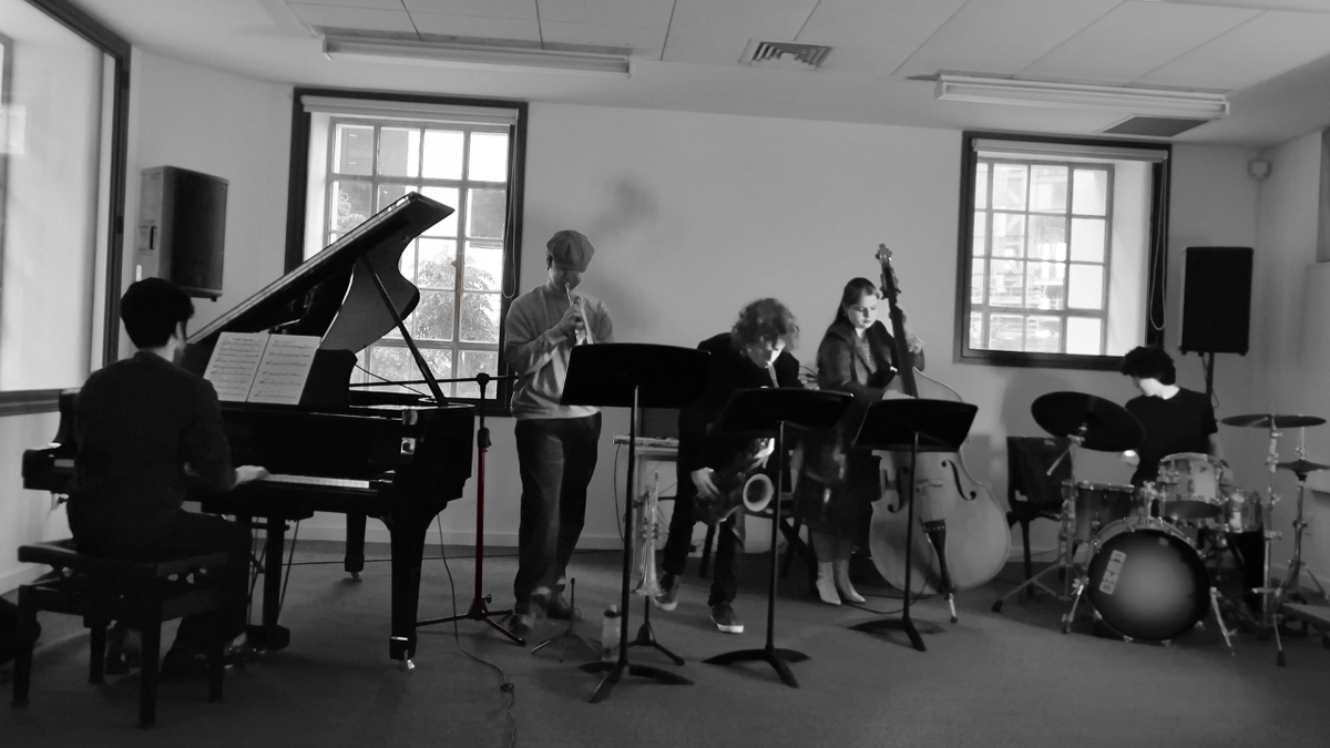 A group of jazz musicians practicing in a room together
