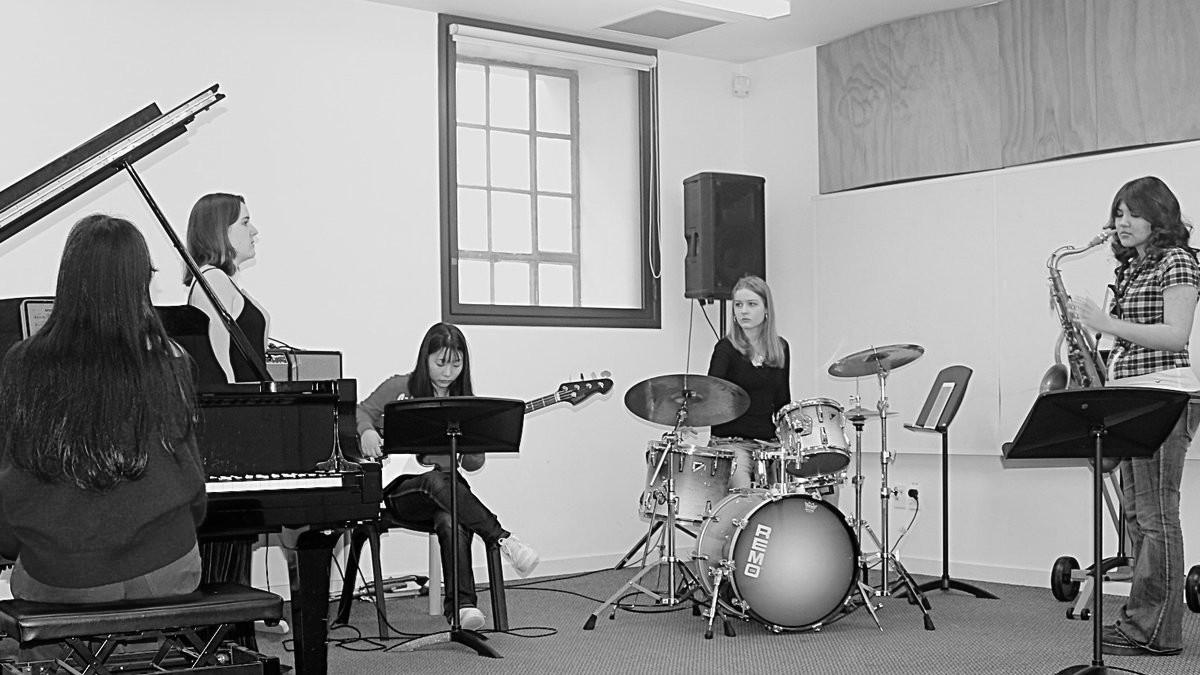 A group of jazz musicians practicing in a room together
