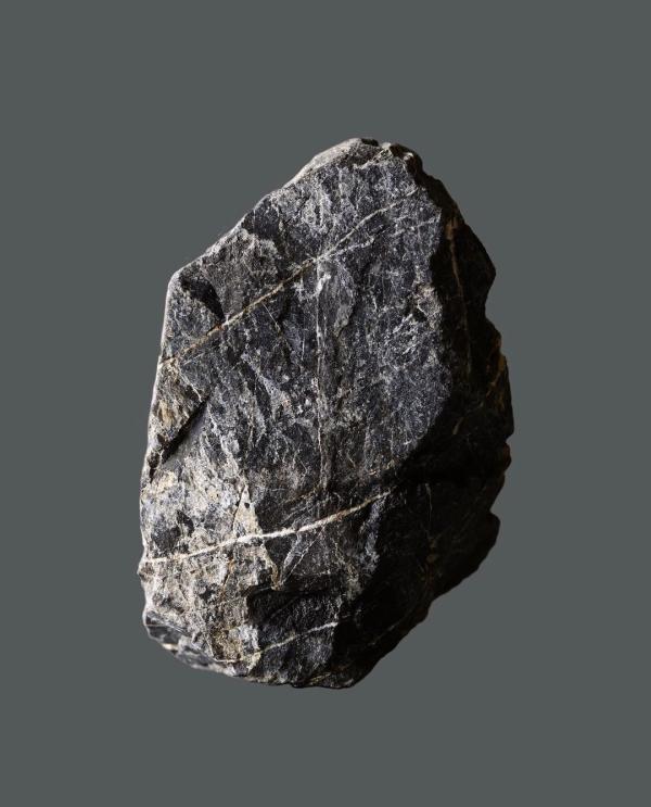 Colour image of a grey rock floating on a dark grey background