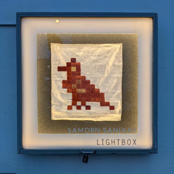 Textile artwork by Samorn Sanixay. Pixelated bird, created from different coloured ribbons that have been hemmed