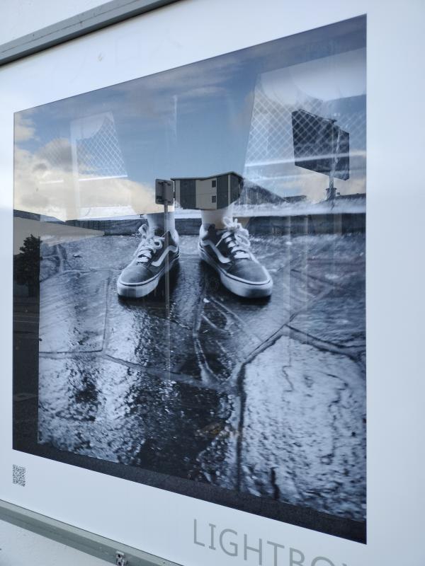 Izakaya Kabu (居酒屋かぶ), a black and white photograph of feet on wet concrete by Tiso Ross sits in the Thistle Hall Lightbox
