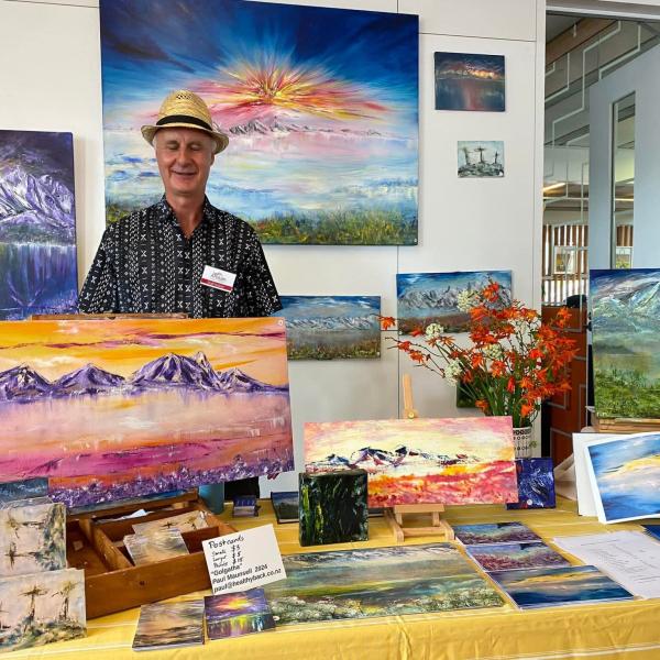 Artist Paul Maunsell photographed with his paintings