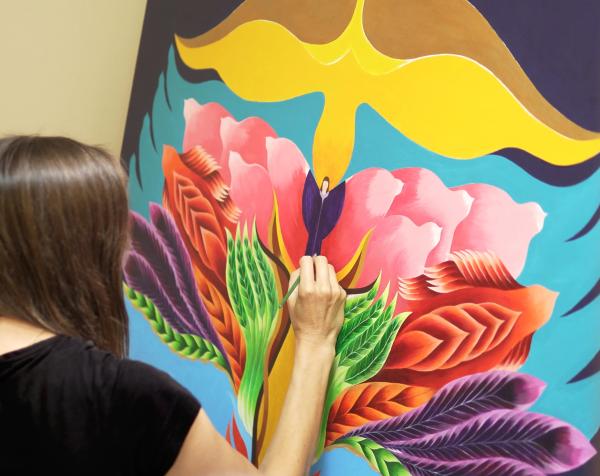 Emily Fletcher painting her work The Tree of Transformation