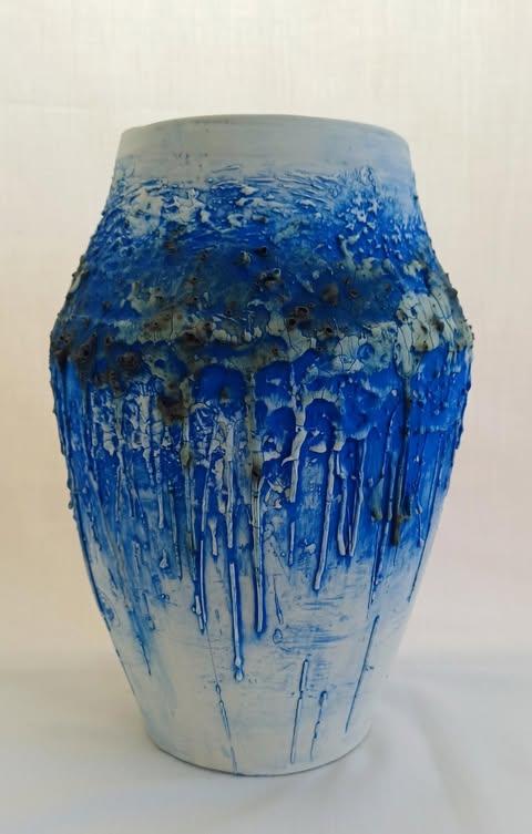 A white vase by Yorka with expressionist blue paint throughout the piece